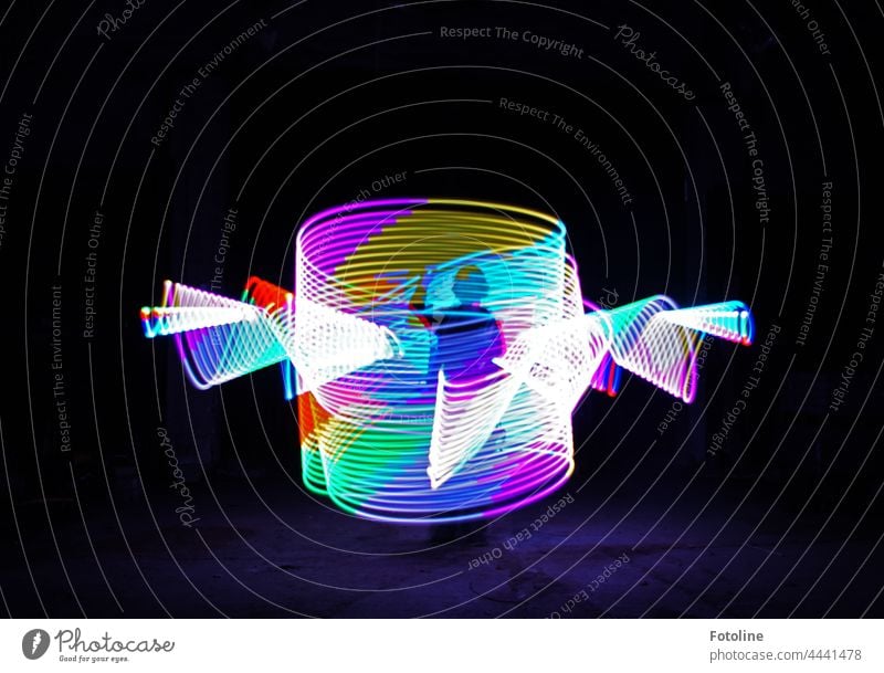 Lightpainting - mit einem Leuchtstab herumgewirbelt und im Inneren die Silhouette erzeugt. Lichtspiel Lichtmalerei Nacht dunkel Linie mehrfarbig Dynamik