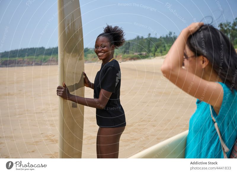 Diverse Surfer mit Surfbrettern im Meer Sportlerinnen Surfen Longboard Zeit verbringen Körper Blauer Himmel Frauen Freundin Neoprenanzug Küste heiter