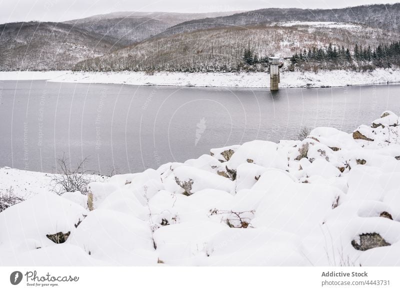 Ein Fluss fließt durch ein verschneites, hügeliges Tal Schnee Baum Winter Landschaft Natur Hügel Ufer Umwelt Wald Wasser strömen Ambitus malerisch fließen kalt