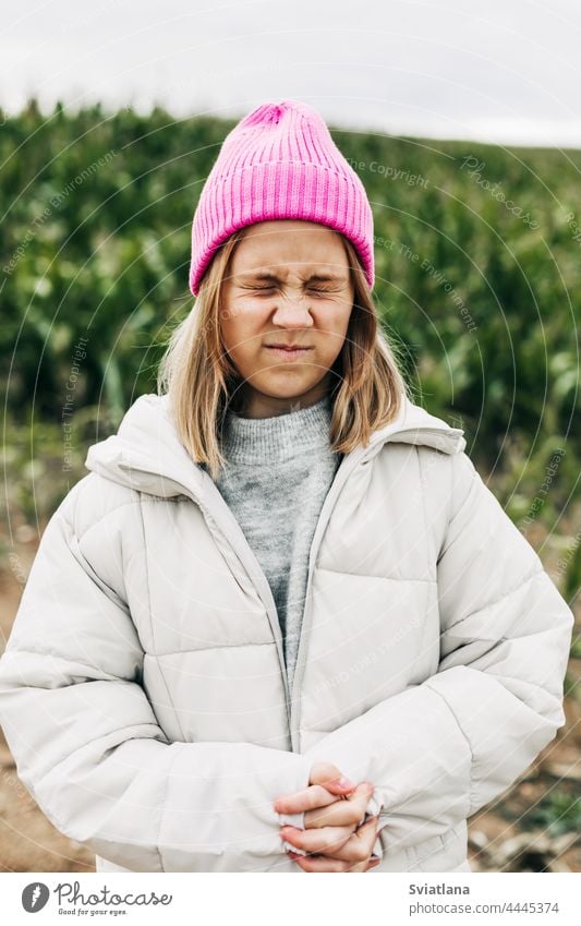 Porträt mit geschlossenen Augen eines lustigen und niedlichen Teenager-Mädchen auf einem Hintergrund von einem grünen Feld mit Mais Stil modisch Lifestyle