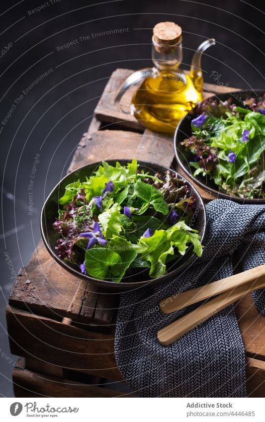 Leckerer Salat und Wildblumensalat in Schalen auf dunklem Hintergrund Salatbeilage gesunde Ernährung Vegetarier Gemüse natürlich frisch Erdöl lecker Vitamin