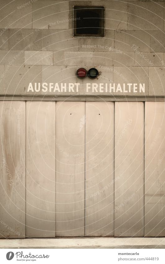 Untermieter | Untervermietet Haus Tor Parkhaus Mauer Wand Ampel Garagentor Stein Beton Stahl Hinweisschild Warnschild einfach kalt trist grau silber Farbfoto