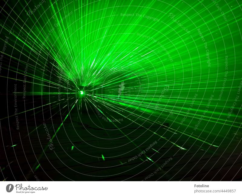 Laserstrahlen breiten sich in einem dunklen Raum aus und machen diesen Ort magisch. Lasershow Licht Nacht dunkel Langzeitbelichtung Farbe grün Dunkelheit