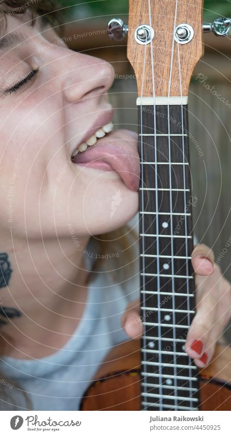 Frau leckt an Gitarre lecken Musik Konzert Rockmusik Freizeit & Hobby Musikinstrument akustisch Farbfoto Gitarrensaite Nahaufnahme Holz musizieren Musiker Saite