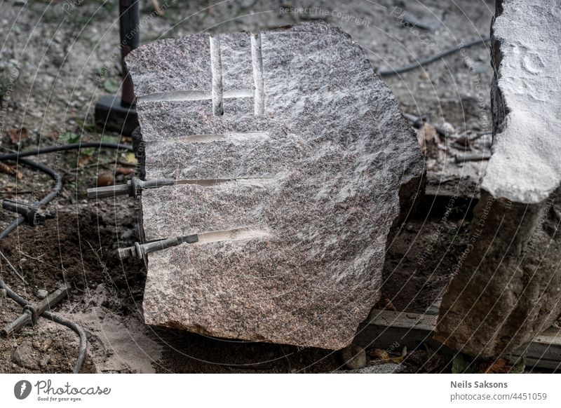 Gespaltener Granitfelsen. Spaltung mit Bohren von Löchern und Tippen Keile. Dann genagelt sie mit dem Hammer, dass Stein in zwei Stücke knacken macht. Verwendet in der Bauindustrie und Steinmetzarbeiten