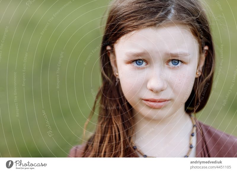 Porträt von traurig weinen emotionale niedliche kleine Mädchen Blick auf die Kamera mit Gesicht der tiefen Traurigkeit und Trauer im Freien. Trauriges Kind mit blauen Augen, Kopie Raum