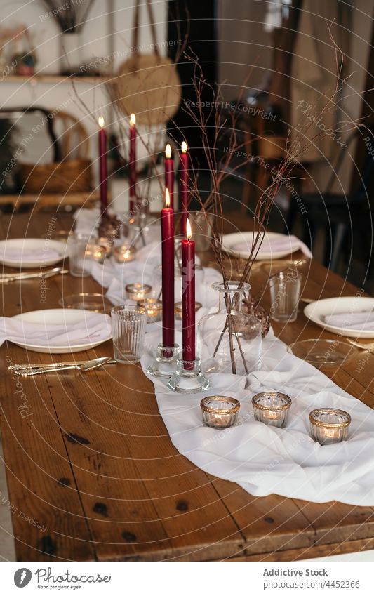 Servierte Festtafel mit brennenden Kerzen Tisch Dekoration & Verzierung Veranstaltung dienen festlich kreativ feiern Teller Design Weihnachten Ast Tischwäsche