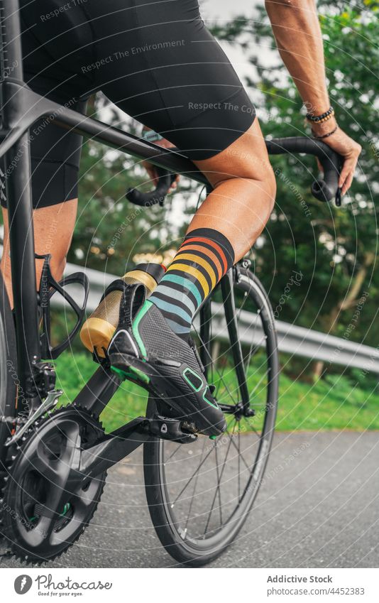 Crop-Radfahrer beim Training auf der Fahrbahn Mitfahrgelegenheit Fahrrad Sport Fahrradfahren Schuh Mann professionell Rennrad Aktivität Straße Sportler modern