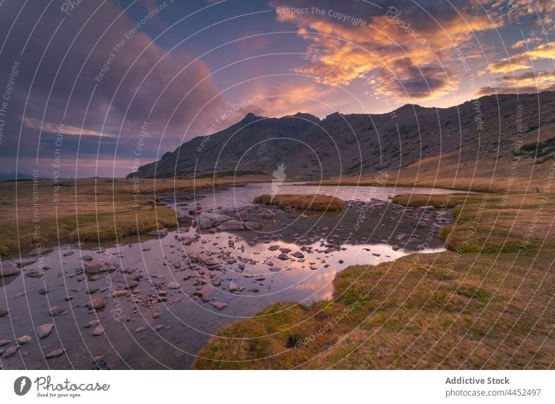 Malerische Landschaft von Fluss gegen Berge unter bunten Himmel bei Sonnenuntergang Berge u. Gebirge Natur See Hochland Felsen malerisch Kamm