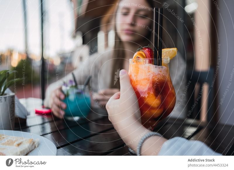 Crop-Teenager mit Cocktails im Gespräch in einem urbanen Cafe bester Freund Snack sich[Akk] sammeln trinken Getränk Inhalt Café Straße Freundin Glas Erfrischung