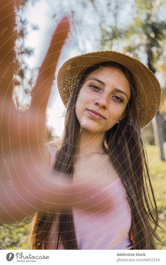 Teenager zeigt Hand im Sommerpark Rahmen Foto Perspektive Bild Lächeln Klammer herzlich Park Porträt freundlich Strohhut Kleidungsstück Fotografie Starrer Blick