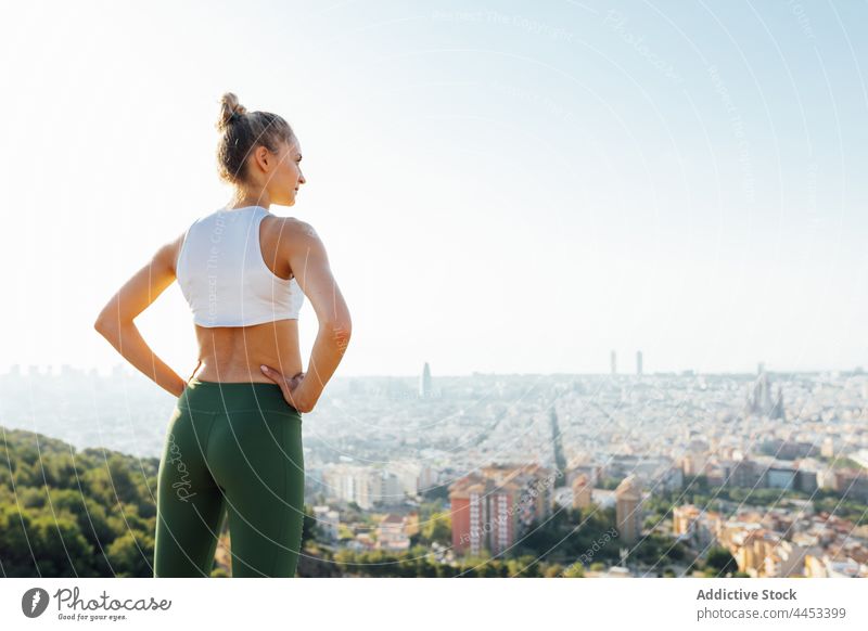 Sportlerin mit Blick auf die Stadt unter bewölktem Himmel Athlet bewundern Stadtbild Hand auf der Taille wolkig Revier Gesunder Lebensstil Pause Frau Großstadt