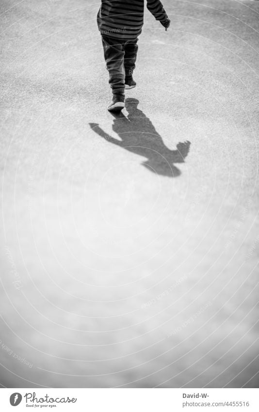 Schatten läuft hinter Kind her laufen Verfolgung anonym Schattenseite Junge Kindheit Schattenspiel Silhouette Schattendasein Traurigkeit Schattenkind