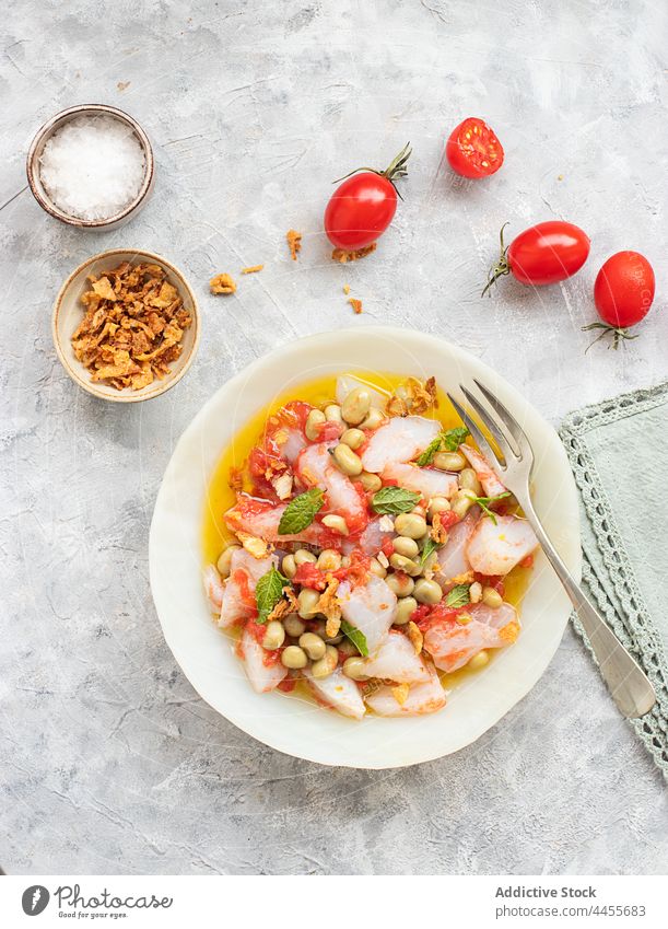 Sommertomaten und Kabeljausalat mit viel Olivenöl farbenfroh Minzblätter Minze Gemüse Tomaten Draufsicht Portion Fava-Bohne nahrhaft natürlich produzieren