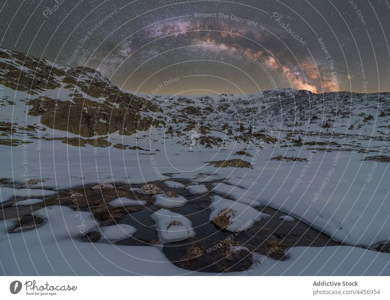 Verschneite Pfütze aus Eiswasser unter nächtlichem Sternenhimmel mit Milchstraße Schnee Berge u. Gebirge Hochland Natur Winter Landschaft Gelände dreckig Kamm