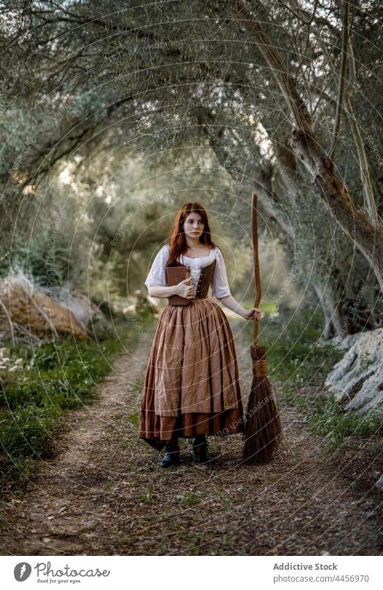 Hexe mit Besenstiel und Buch im Wald Zauberei u. Magie Frau Kleid Zauberin Herbst mystisch Hexerei Zauberer Wälder stehen dumpf trist Halloween ernst dunkel