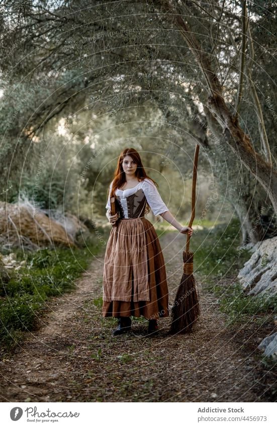 Hexe mit Besenstiel und Buch im Wald Zauberei u. Magie Frau Kleid Zauberin Herbst mystisch Hexerei Zauberer Wälder stehen dumpf trist Halloween ernst dunkel