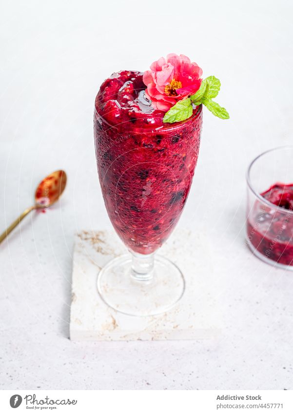 Glas mit Beeren-Smoothie auf dem Tisch dienen süß lecker trinken Erfrischung Gesundheit Dessert geschmackvoll organisch Blume Garnierung Leckerbissen Getränk