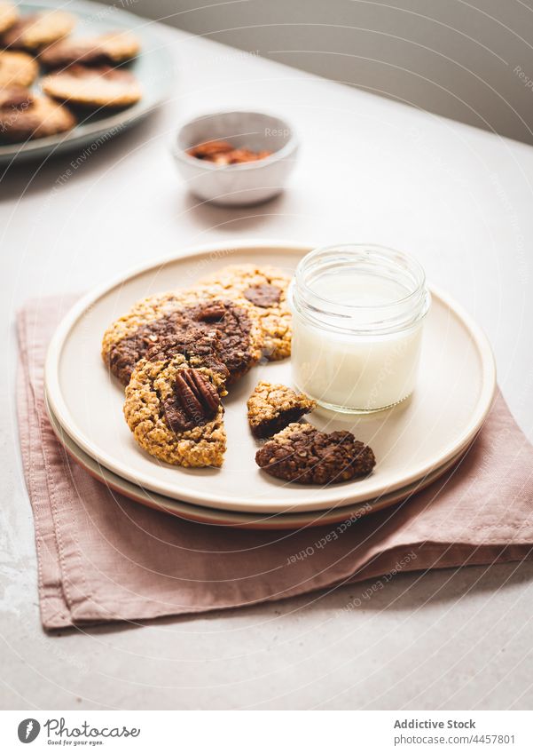 Milch und Kekse auf dem Teller melken Glas Walnussholz Dessert Tisch dienen süß Leckerbissen lecker Snack Nut geschmackvoll frisch Ernährung Lebensmittel