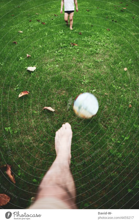 Vater und Sohn spielen Fußball Ball Garten Wiese gemeinsam zusammen Kind Spaß schießen