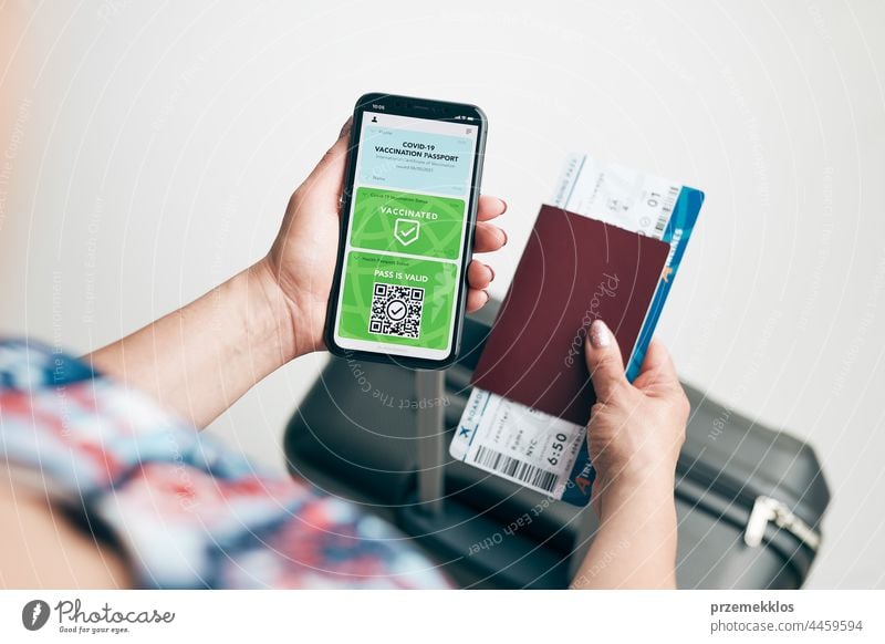 Digitales Covid-Zertifikat. Covid negativer digitaler Schnelltest-Pass. Passagierin hält digitalen medizinischen Pass auf ihrem Handy, Reisepass und Flugticket. Reisender zeigt digitales Covid-Testergebnis als medizinischen Pass für sicheres Reisen