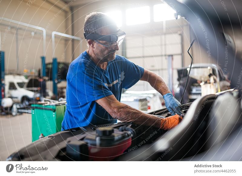 Männlicher Mechaniker bei der Reparatur eines Autos in einer Werkstatt fixieren PKW Motor Dienst Mann Automobil Meister männlich Fahrstuhl Techniker Arbeit