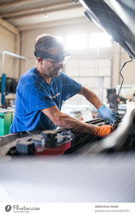 Männlicher Mechaniker bei der Reparatur eines Autos in einer Werkstatt fixieren PKW Motor Dienst Mann Automobil Meister männlich Fahrstuhl Techniker Arbeit