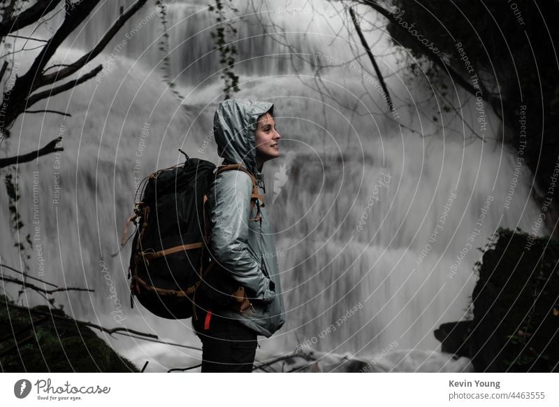 Mädchen vor einem Wasserfall Außenaufnahme Natur Farbfoto Fluss nass fließen Felsen Wald Rucksack natürlich