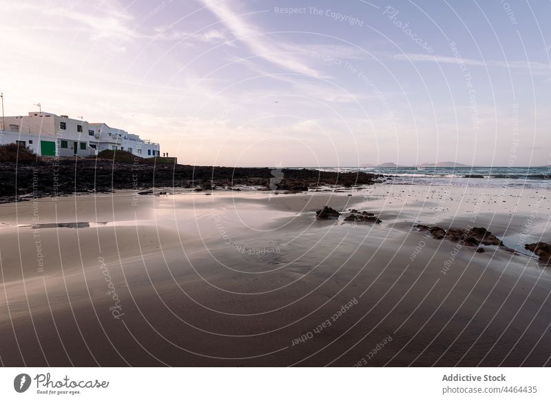 Seeufer gegen Gebäude und Berge am Abend Ufer MEER Himmel wolkig Natur Landschaft Hochland Architektur Strand Berge u. Gebirge Meer Insel malerisch Teguise