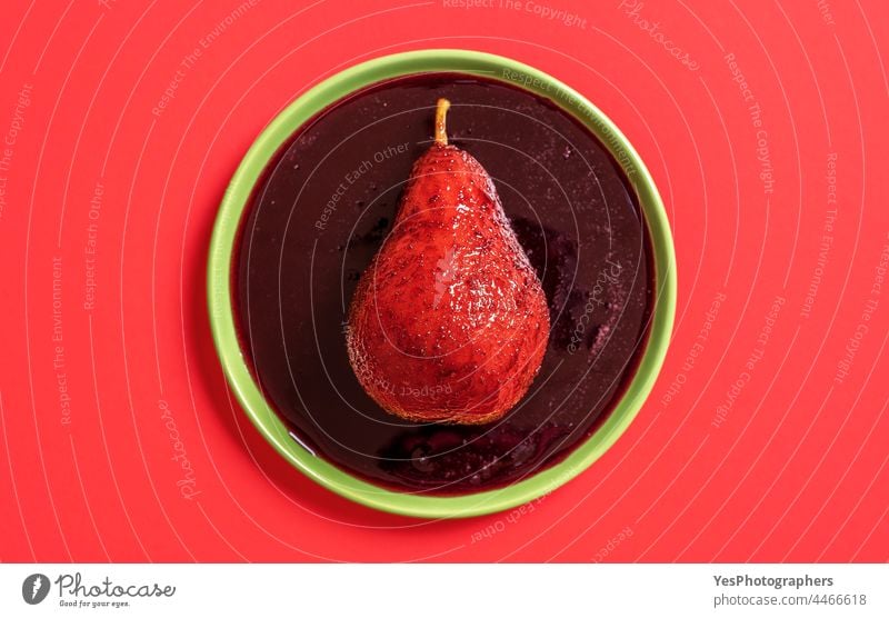 Rotweinpochierte Birne auf dem Teller, Ansicht von oben. Alkohol Herbst Hintergrund gekocht Weihnachten Farbe Küche ausschneiden lecker Dessert Diät