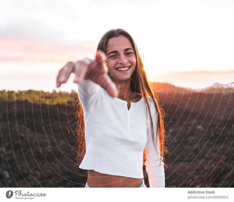 Lächelnder Teenager mit langen Haaren am Meer in den Bergen ausdehnen freundlich herzlich charmant Berge u. Gebirge Sonnenuntergang Himmel Porträt Reittier