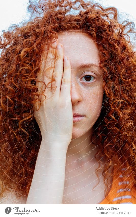 Ernste Frau, die ihr Gesicht mit der Hand bedeckt Porträt Sommersprosse Funktion Rotschopf Vorschein Individualität Starrer Blick starren Persönlichkeit