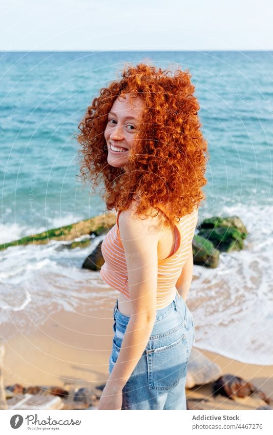 Fröhliche Frau am Meeresufer stehend Glück blau MEER Wind Ufer froh Urlaub Feiertag Freude heiter lange Haare Rotschopf Wasser Natur Optimist Ingwerhaar positiv