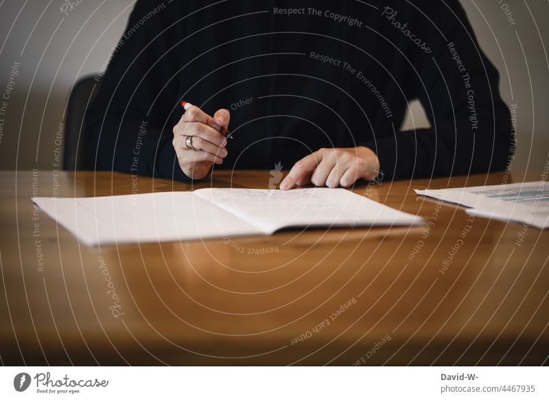 Frau lernt / überprüft mit einem Stift in der Hand ein Heft Lehrerin Lernen kontrollieren stift Bildung Schreibtisch Schule Studium studentin Spiegelung Konzept