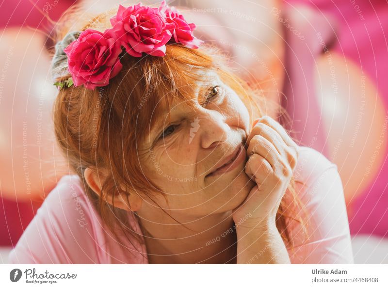 Verträumt in Rosa - Frau mit Rosen im Haar schaut verträumt, während sie ihren Kopf auf stütz rothaarig Haarschmuck Hipster Kinn auf stützen Haare & Frisuren