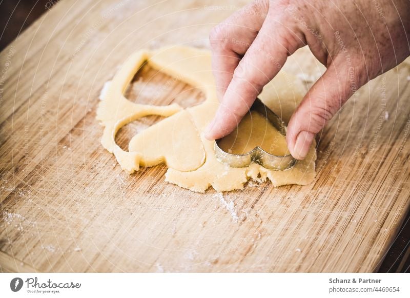 Hand beim Plätzchen ausstechen Weihnachten Zuckerguss Vorweihnachtszeit Advent backen Adventszeit Weihnachtsgebäck Kindheit Backblech Backpapier Teig süß