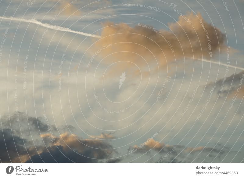 Abendlicher Himmel II mit orange, gelb, blau, weiß und grau, der durch einen Kondensstreifen geprägt ist, in horizontaler Aufnahme und freundlicher Stimmung.