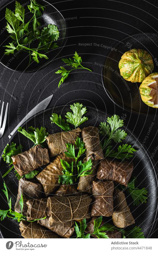 Teller mit leckerem Sarma-Gericht mit Petersilie und Zitrone Gabel Messer schmackhaft dolma Fleisch Traube Blätter Speise geschmackvoll Küche Bestandteil