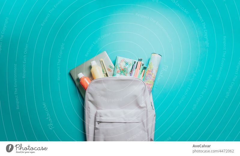 Rucksack mit bunten Schulsachen auf lila Hintergrund. Zurück zur Schule. Flachlage, Draufsicht, Kopierraum, Minimaldesign Rücken Tafel Hochschule Bildung Lernen