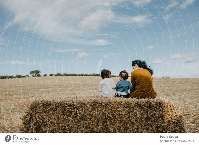 Mutter mit Kindern auf Heuballen sitzend Mutterschaft Kindheit Feld Bereiche Herbst Zusammengehörigkeitsgefühl Glück Liebe Eltern Familie & Verwandtschaft