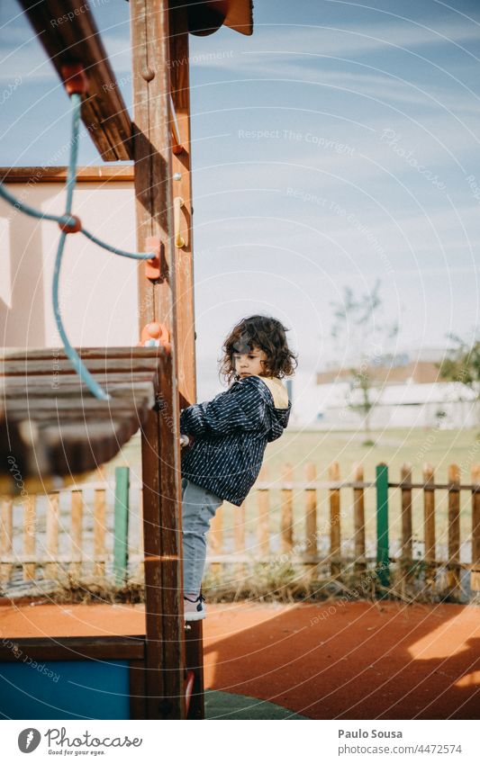 Seitenansicht Mädchen spielt auf Spielplatz Kind eine Person Kaukasier 1-3 Jahre Spielen Schule Spielplatzgeräte Kindheit Außenaufnahme Farbfoto niedlich Park