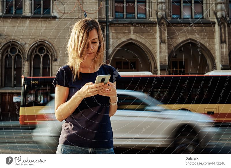 Frau benutzt Smartphone auf einer Straße in der Stadt Mobile laufen Lifestyle Kommunizieren online Porträt Telefon benutzend Fröhlichkeit tragbar Information