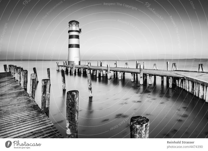 Leuchtturm Podersdorf bei Sonnenaufgang Steg Wasser See Schwarzweißfoto schwarzweiß sw Stimmungsbild Landschaft Ruhe Licht Schatten besonderes Licht einzigartig