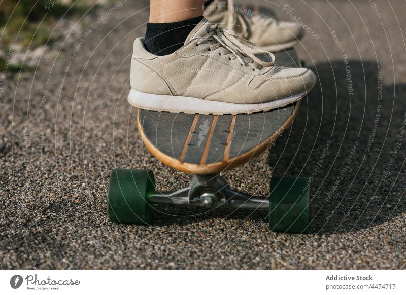 Anonyme Frau fährt Longboard auf einer asphaltierten Straße Mitfahrgelegenheit Aktivität Hobby genießen Freizeit Natur Gleichgewicht wolkig Training Hügel