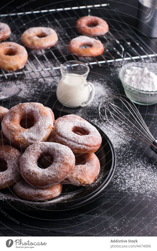 Leckere Krapfen mit Puderzucker Doughnut gebraten Dessert Pulver Zucker süß Gebäck Kalorie Konditorei melken Teller Ablage unordentlich Lebensmittel