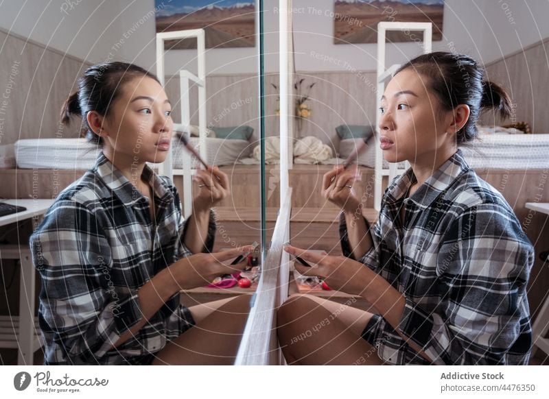 Junge Frau, die sich vor dem Spiegel schminkt Make-up Schlafzimmer Pulver Vorschein Reflexion & Spiegelung Routine Licht heimwärts asiatische Frau ethnisch jung