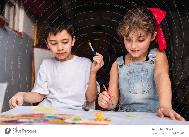 Fröhliche Kinder malen am Tisch Farbe Hobby Kunst Pinselblume Kindheit Papier Handwerk Wasserfarbe positiv farbenfroh heiter Inhalt Licht kreativ niedlich