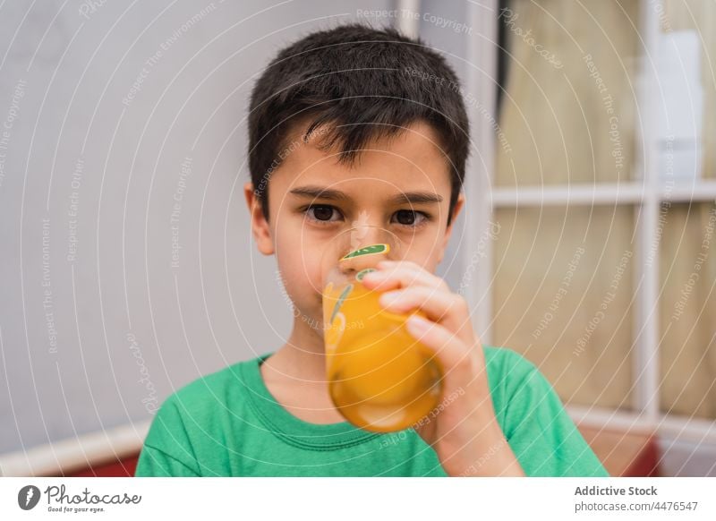 Junge trinkt Saft aus einem Glas Kind Getränk Durst trinken Kindheit Erfrischung süß Raum heimwärts ernst Licht nachdenklich heimisch Stil Windstille lässig