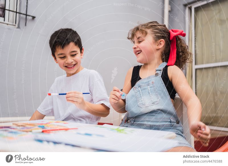 Fröhliche Kinder malen am Tisch Farbe Hobby Kunst Pinselblume Kindheit Papier Handwerk Wasserfarbe positiv farbenfroh heiter Inhalt Licht kreativ niedlich