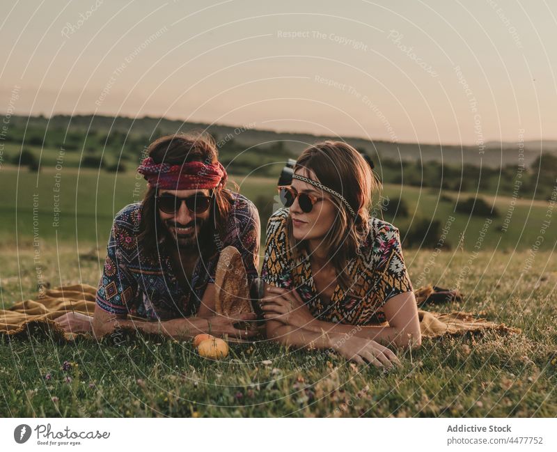 Pärchen schaut weg, während es auf einer Wiese liegt Frau Natur Inhalt positiv friedlich Gelassenheit Feld Landschaft Gras Lifestyle sorgenfrei romantisch Blume